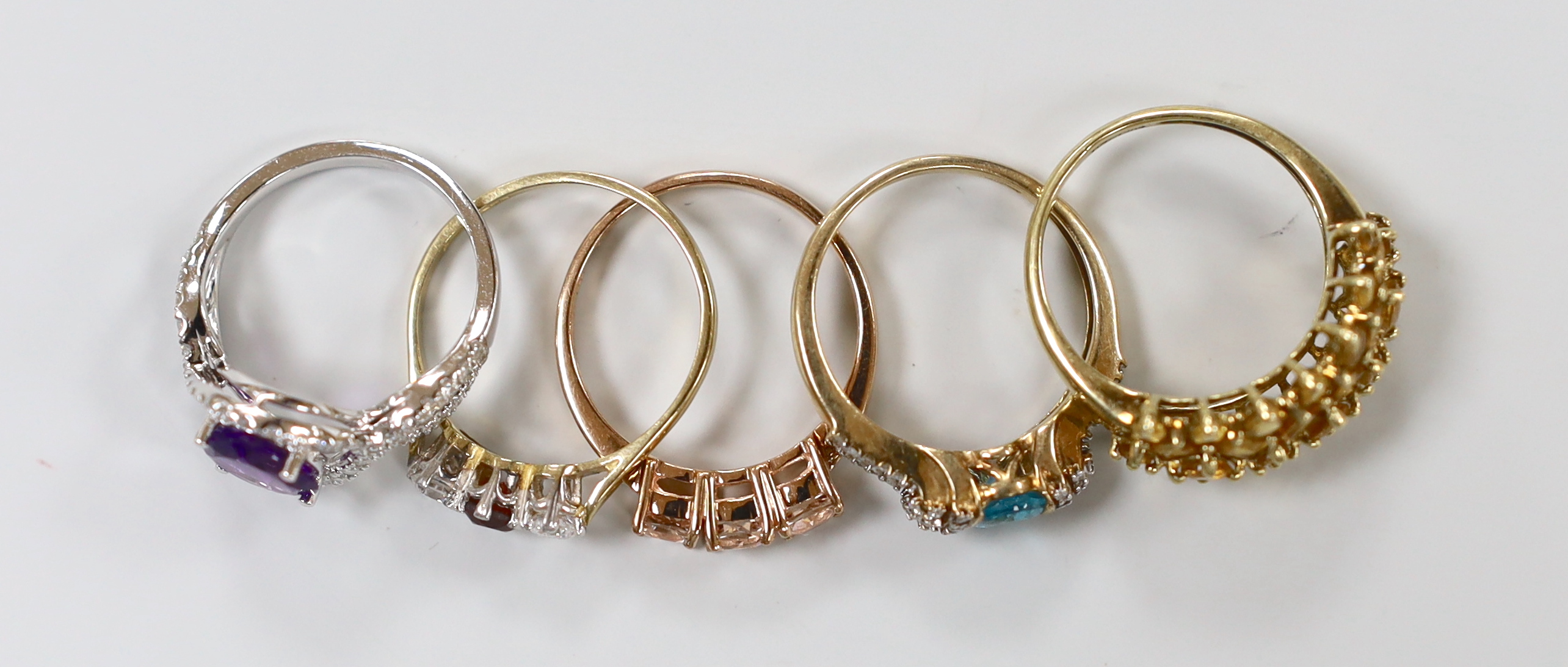 Five assorted modern 9ct gold and gem set rings including a white gold, amethyst and diamond ring, gross weight 12.6 grams.
